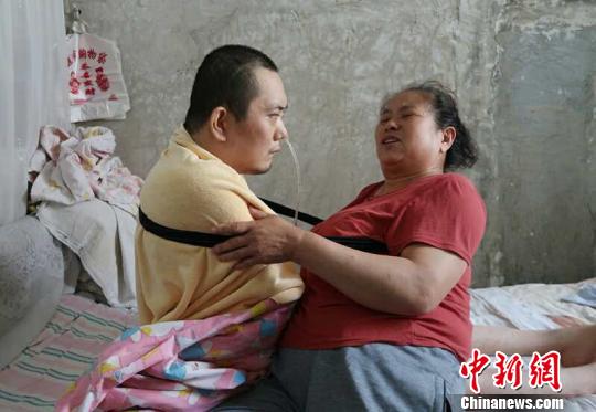 身體日漸衰老的梁青蘭每次幫兒子翻身、坐立，全身的衣物都要濕透一次?！∩忻鱾b 攝