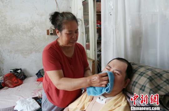 每次喂完食物后，梁青蘭都要仔細(xì)地幫兒子清理干凈?！∩忻鱾b 攝