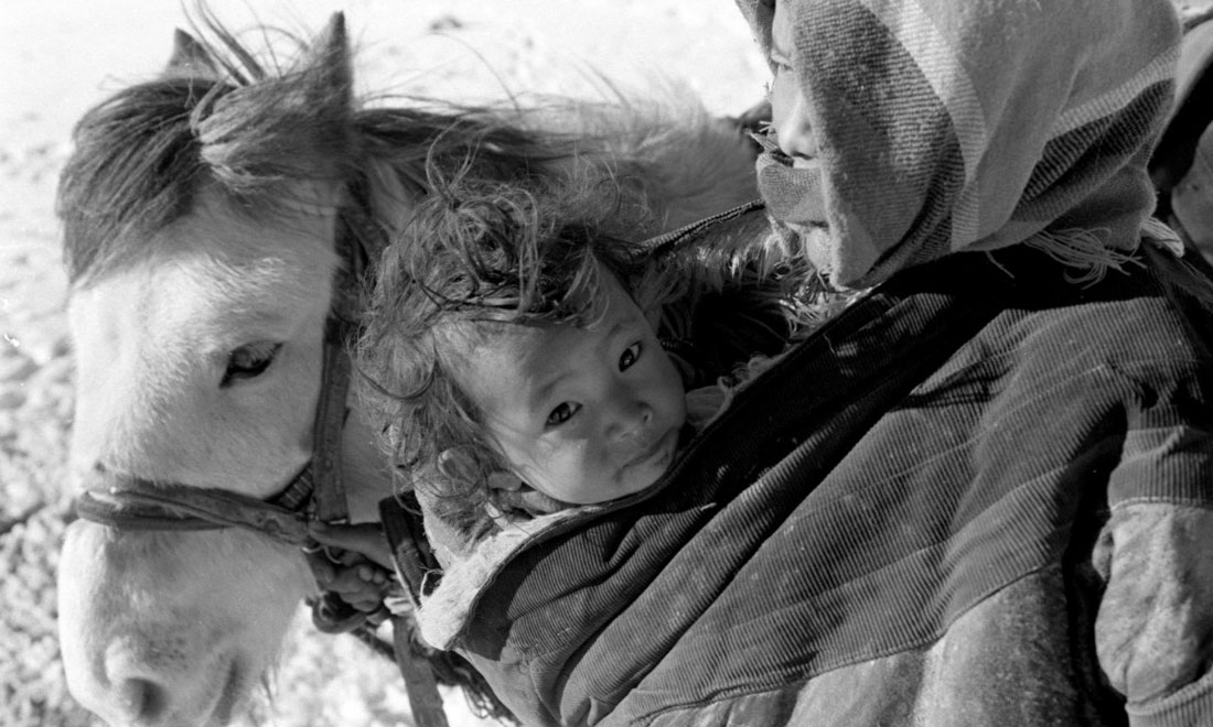 1990年3月，西藏當(dāng)雄縣納木湖鄉(xiāng)三村女牧民斯卓不畏嚴(yán)寒，懷抱幼子，準(zhǔn)備到遠處放牧。新華社記者覺果攝