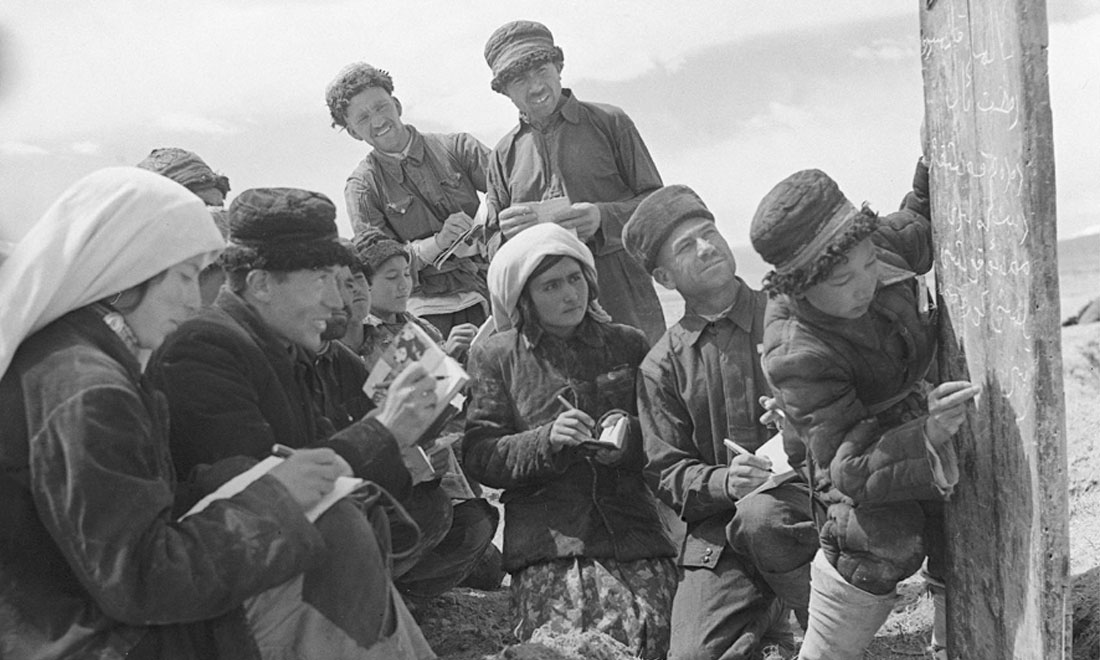 1960年6月，新疆慕士塔格峰下，大人們在小學(xué)生幫助下學(xué)習(xí)文化。新華社記者武純展攝