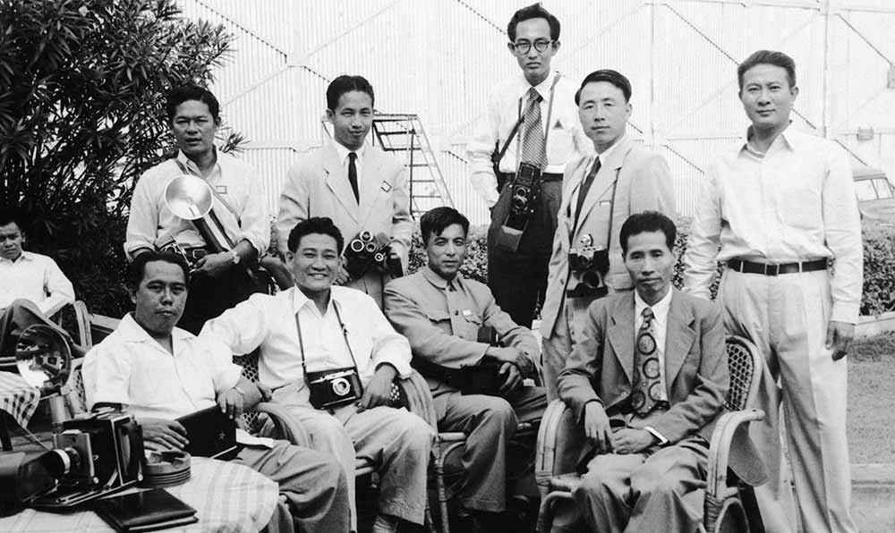 新華社記者錢嗣杰（站立者右二）在采訪會議開幕式后和外國記者在會場外休息。