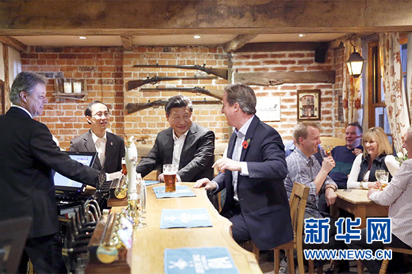 這是會晤結(jié)束后，習(xí)近平在卡梅倫陪同下乘車前往當(dāng)?shù)匦℃?zhèn)體驗酒吧文化。新華社記者 鞠鵬 攝